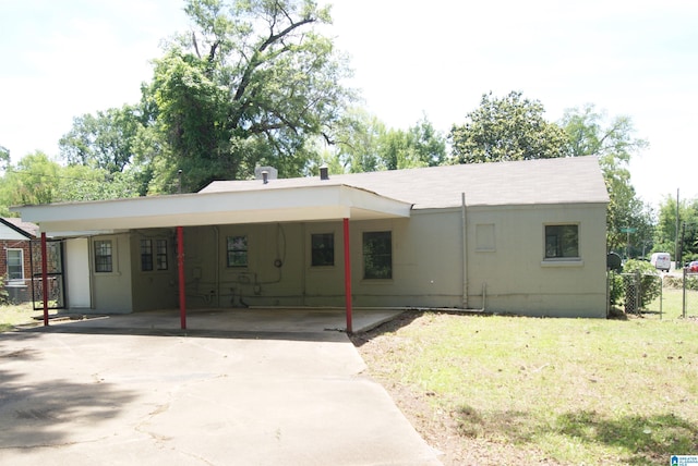 rear view of house featuring a carport and a lawn