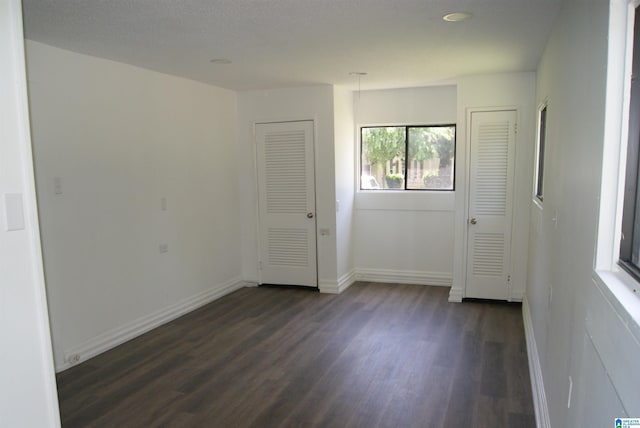 unfurnished room with dark hardwood / wood-style flooring