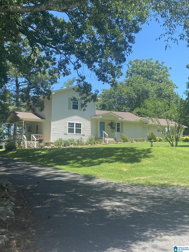 view of front of house with covered porch and a front lawn