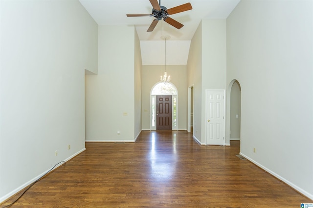 entrance foyer featuring ceiling fan with notable chandelier, dark hardwood / wood-style flooring, and high vaulted ceiling