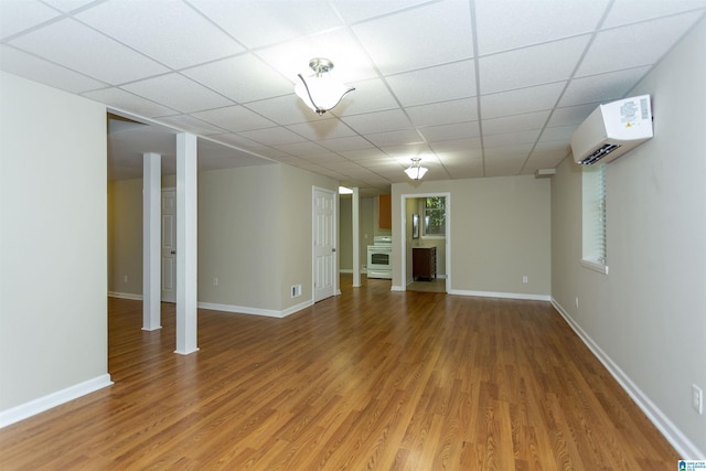 basement with a wall mounted air conditioner and hardwood / wood-style flooring