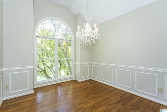 unfurnished dining area featuring dark hardwood / wood-style floors, lofted ceiling, and an inviting chandelier