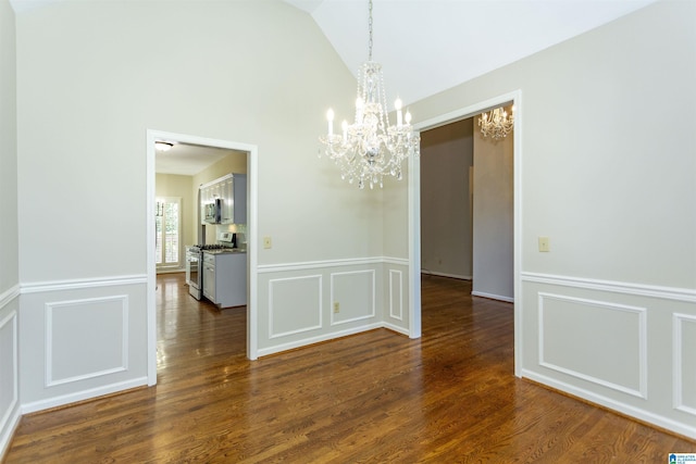 unfurnished dining area featuring dark hardwood / wood-style flooring, lofted ceiling, and an inviting chandelier