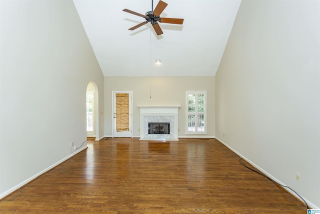 unfurnished living room with ceiling fan, dark hardwood / wood-style flooring, a fireplace, and high vaulted ceiling