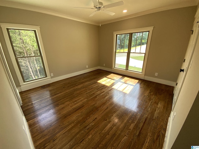 unfurnished room with ceiling fan, a healthy amount of sunlight, dark hardwood / wood-style flooring, and ornamental molding