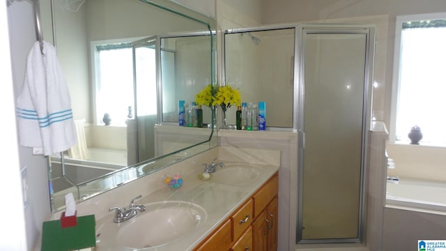 bathroom featuring independent shower and bath, double sink, and oversized vanity