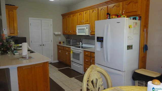 kitchen featuring white appliances, sink, and light tile flooring