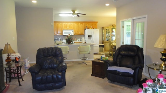 living room with ceiling fan and light colored carpet