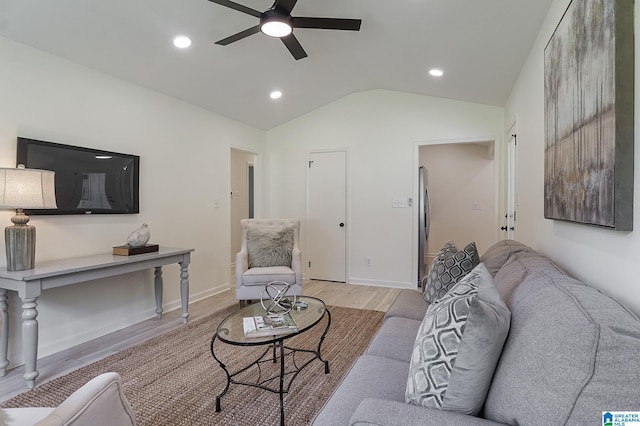 living room featuring ceiling fan, vaulted ceiling, and light hardwood / wood-style flooring