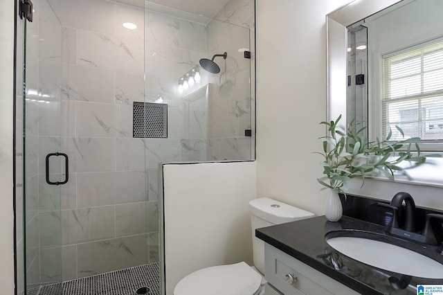 bathroom with toilet, an enclosed shower, and vanity