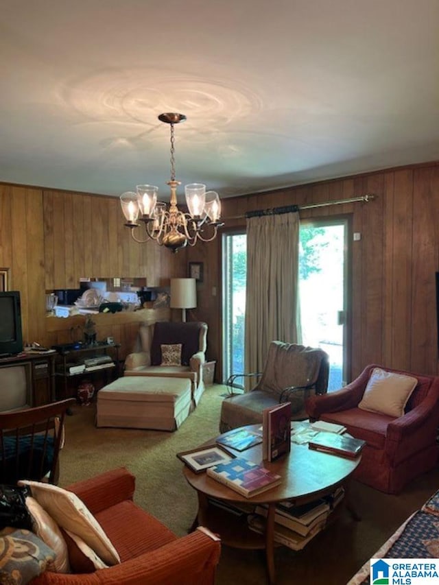 living room featuring carpet flooring, wooden walls, and a chandelier