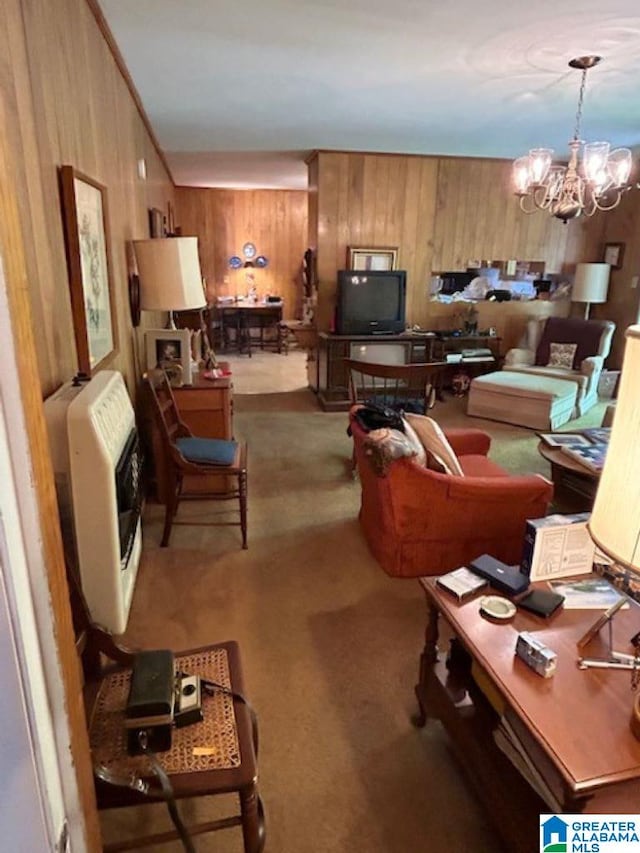 living room with carpet, heating unit, wooden walls, and a chandelier