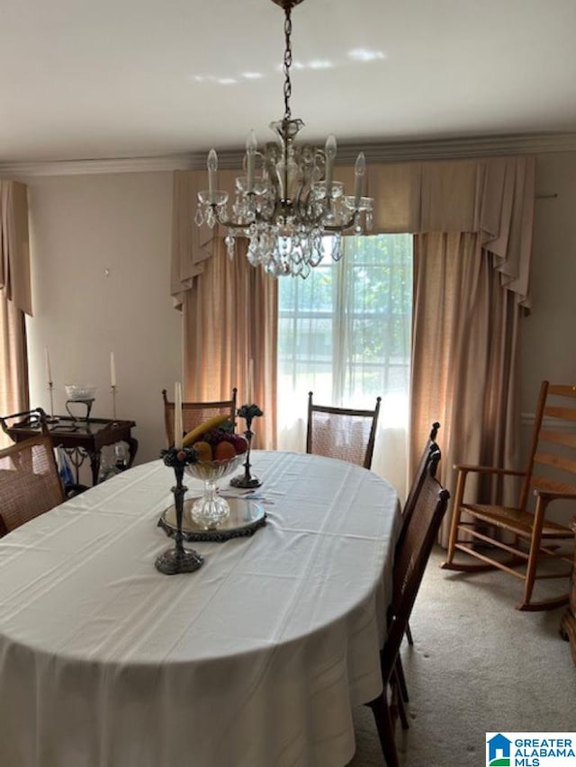 carpeted dining space featuring a chandelier and ornamental molding