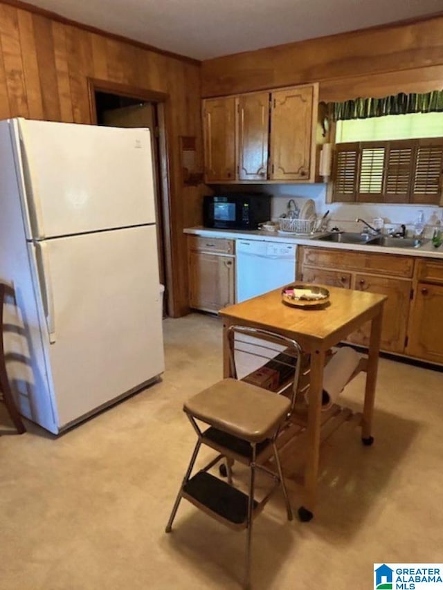 kitchen with wood walls, white appliances, and sink