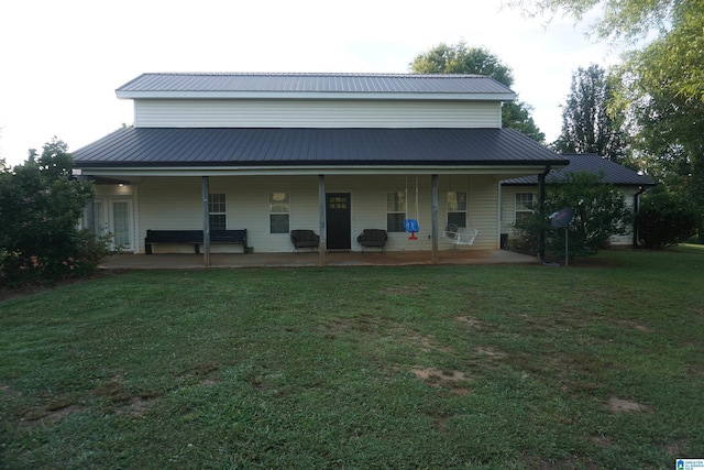 rear view of house with a lawn and a porch