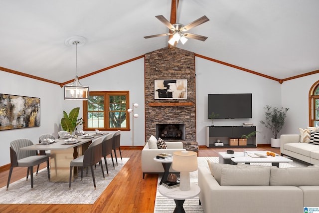 living room with a fireplace, vaulted ceiling, light hardwood / wood-style flooring, and ceiling fan with notable chandelier