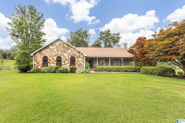 873 Buckelew Rd, Anniston, AL 36207 - view of front of house with a front yard, a chimney, stone siding, and covered porch