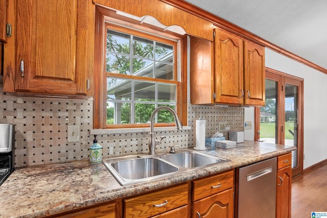 873 Buckelew Rd, Anniston, AL 36207 - kitchen with a sink, dishwasher, brown cabinets, backsplash, and light countertops
