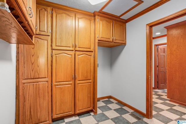 873 Buckelew Rd, Anniston, AL 36207 - kitchen featuring light floors, crown molding, brown cabinets, and baseboards
