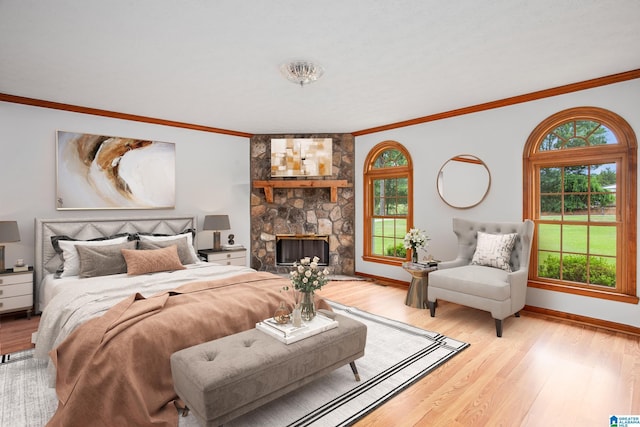 bedroom with ornamental molding, a fireplace, and light hardwood / wood-style flooring