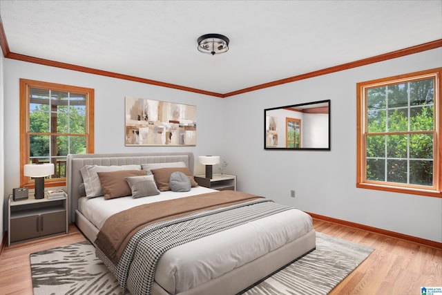 bedroom with ornamental molding and light hardwood / wood-style flooring