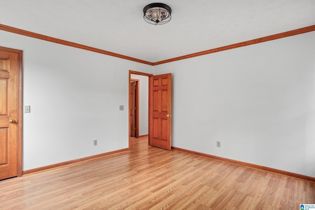 empty room with light wood-type flooring and crown molding