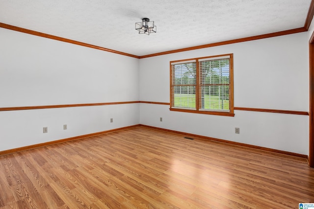 unfurnished room with a textured ceiling, light wood-type flooring, and ornamental molding