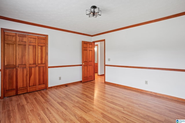 unfurnished bedroom featuring a closet, light hardwood / wood-style flooring, and ornamental molding