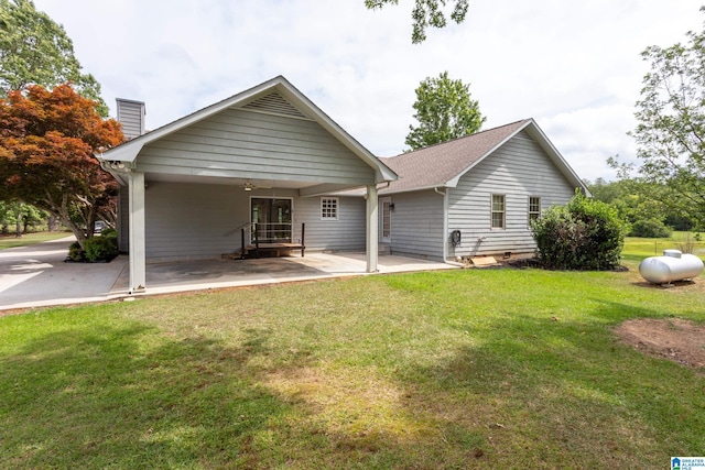 back of property with a yard, a patio, and ceiling fan