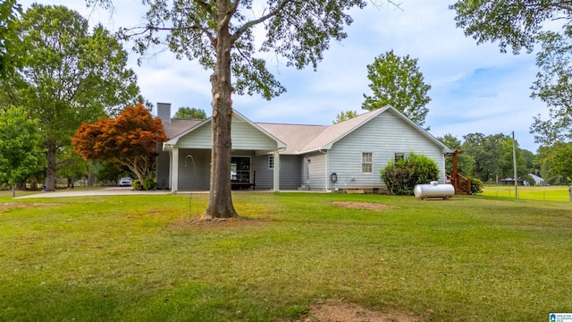 ranch-style home featuring a carport and a front yard