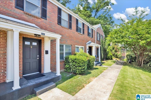 view of exterior entry with a yard