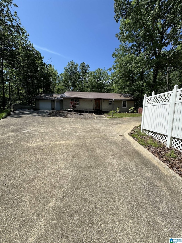 459 Tyler Rd, Remlap, AL 35133 - view of front of house featuring a garage, fence, driveway, view of scattered trees, and metal roof