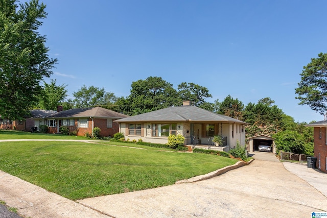 view of front of property with an outbuilding, a garage, and a front lawn