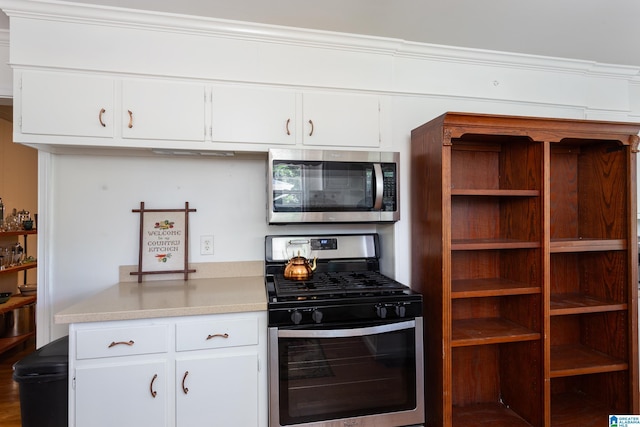 kitchen featuring appliances with stainless steel finishes, white cabinetry, and ornamental molding