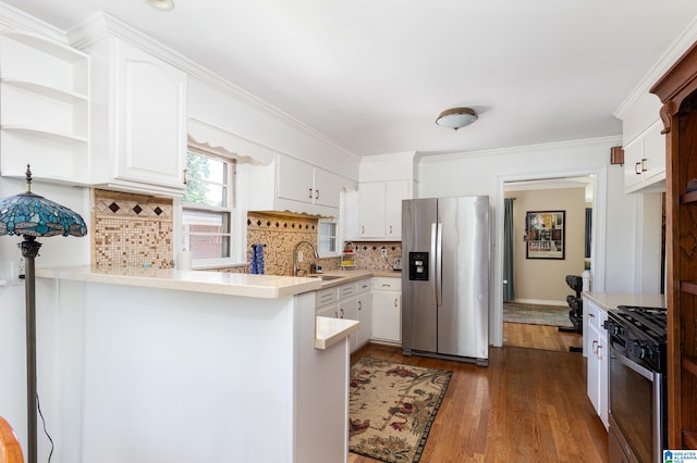 kitchen featuring kitchen peninsula, appliances with stainless steel finishes, decorative backsplash, sink, and white cabinetry