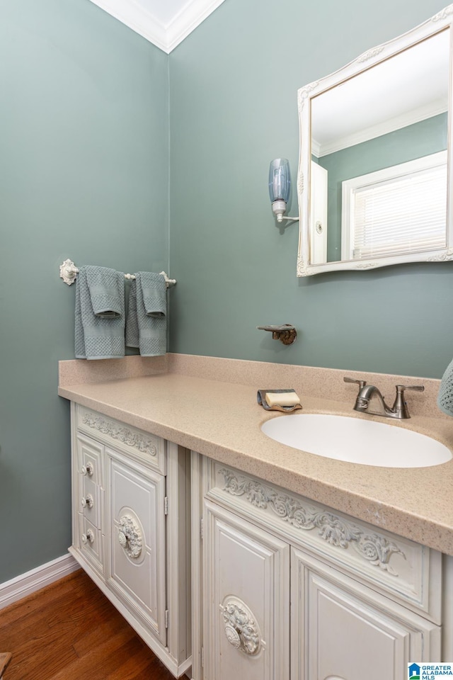 bathroom featuring crown molding, hardwood / wood-style floors, and vanity