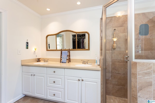 bathroom featuring a shower with shower door, ornamental molding, and vanity