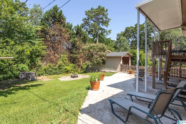 view of yard featuring a patio, an outdoor fire pit, an outdoor structure, and a wooden deck