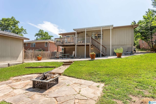 back of property featuring a fire pit, a patio, and a lawn