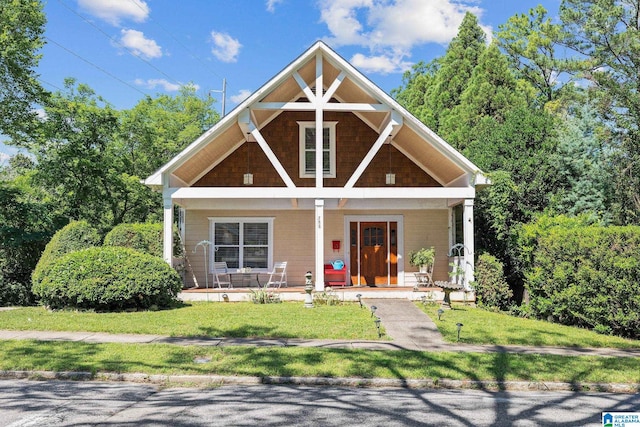 view of front of home with covered porch and a front lawn
