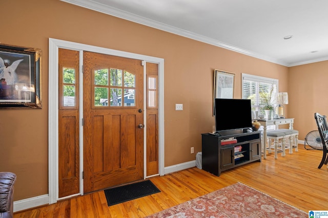 entrance foyer with ornamental molding and light wood-type flooring