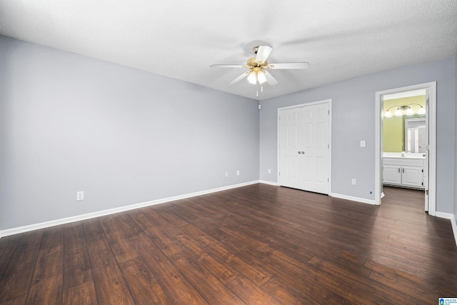 unfurnished bedroom featuring ceiling fan, dark hardwood / wood-style flooring, ensuite bathroom, and a textured ceiling