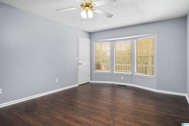 empty room with dark hardwood / wood-style floors, ceiling fan, and a textured ceiling