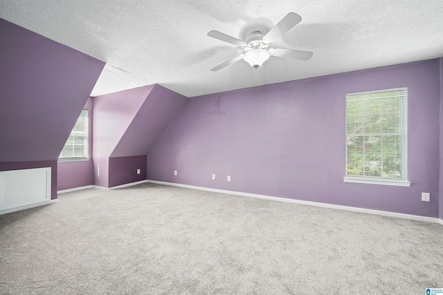 bonus room featuring a textured ceiling, carpet floors, vaulted ceiling, and ceiling fan