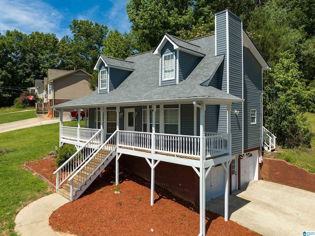 new england style home with a front lawn, a porch, and a garage