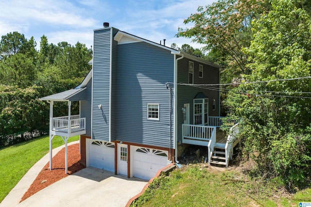 view of side of property with a porch, a yard, and a garage