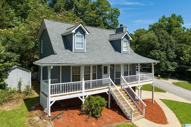 view of front of home with covered porch and a shed