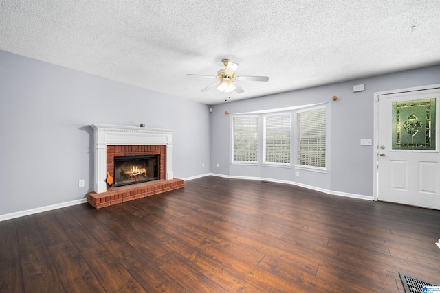 unfurnished living room featuring a fireplace, dark hardwood / wood-style flooring, a healthy amount of sunlight, and a textured ceiling