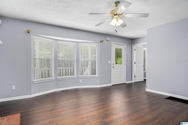 spare room featuring a textured ceiling, ceiling fan, and dark hardwood / wood-style floors