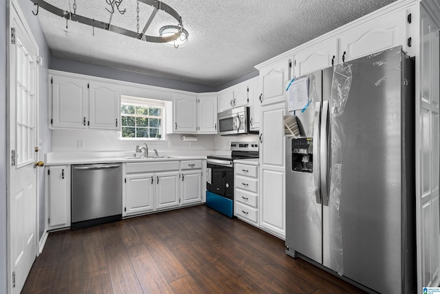 kitchen with a textured ceiling, stainless steel appliances, dark wood-type flooring, sink, and white cabinets